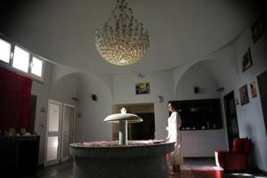 Eine Frau im weißen Bademantel steht neben einer Brunnenskulptur im Paradis Palace.