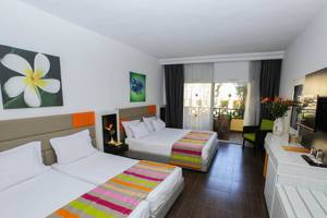 Doppelzimmer im Paradis Palace Hotel mit zwei Betten, farbenfroher Bettwäsche und Balkon.