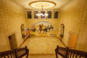 Innenansicht der Halle im Nour Palace Resort & Thalasso mit Wandgemälde und Treppen.