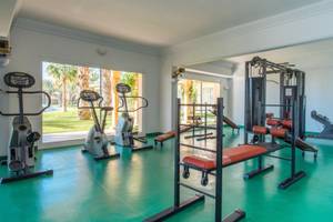 Fitnessstudio im Iberostar Waves Averroes Hotel mit grünem Boden und Geräten