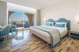 Schlafzimmer im Iberostar Waves Averroes Hotel mit Balkon, Bett und Möbeln.