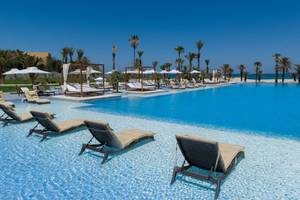 Außenpool des JAZ Tour Khalef Hotels mit Liegen und Sonnenschirmen