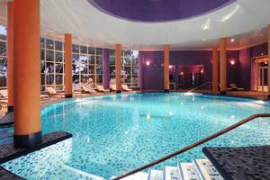 Innenpool im JAZ Tour Khalef Hotel mit blauen Fliesen und orangefarbenen Säulen.