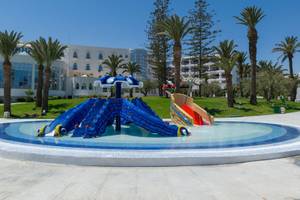 Wasserspielplatz des JAZ Tour Khalef Hotels mit bunten Rutschen vor weißem Gebäude