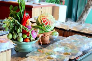 Buffet-Tisch im Banana Fan Sea Resort mit Gemüse, Obst und vorbereiteten Gerichten.