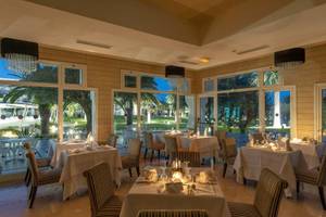 Innenansicht des Restaurants des JAZ Tour Khalef Hotels mit großen Fenstern und gedeckten Tischen.