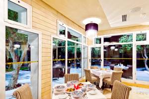 Innenansicht des Speisesaals im Jaz Tour Khalef Hotel mit großen Fenstern und moderner Einrichtung.