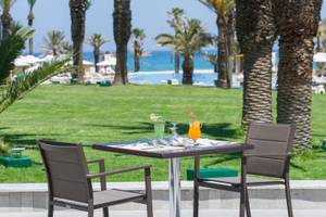 Gartentisch mit Getränken im JAZ Tour Khalef Hotel mit Blick auf den Ozean