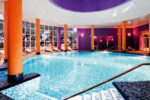 Innenpool im JAZ Tour Khalef Hotel mit blauen Fliesen und orangefarbenen Säulen.