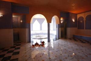Innenbereich des JAZ Tour Khalef Hotels mit einem Schwimmbad und Marmorboden.
