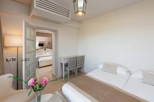 Innenansicht eines Doppelzimmers im JAZ Tour Khalef Hotel mit zwei Betten, Tisch, Stühlen und Dekoration.
