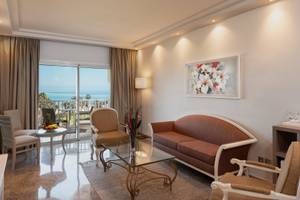 Hotelzimmer im JAZ Tour Khalef mit Meerblick, modern eingerichtet mit Couch, Tisch und Fenstern.