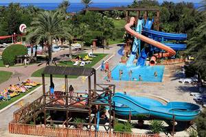 Ein Wasserpark mit Rutschen und Pool, viele Gäste entspannen und spielen.