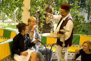 Gäste im Sahara Beach AquaPark Resort sitzen und rauchen Shisha an einem runden Tisch.