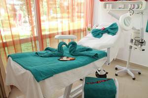 Behandlungszimmer im Sahara Beach AquaPark Resort mit grünen Handtüchern und Blick auf den Garten.