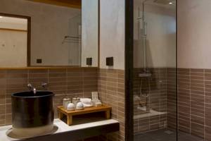 Badezimmer im Banana Fan Sea Resort mit schwarzem Waschbecken und braunen Fliesen.
