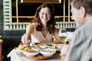 Frau und Mann essen im Iberostar Selection Kantaoui Bay Hotel mit verschiedenen Gerichten auf einem Tablett