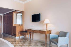 Innenansicht eines Hotelzimmers von Iberostar Selection Kantaoui Bay mit Bett, Schreibtisch, Stuhl und Fernseher.