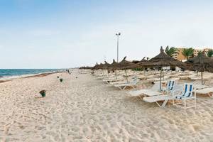 Sandiger Strand des Sentido Bellevue Park Hotels mit Liegen und Sonnenschirmen.
