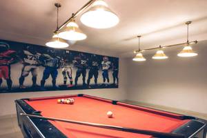 Ein Pooltisch in einem Raum des Hotels Iberostar Selection Diar El Andalous, mit einer Wandbild von American Football Spielern.