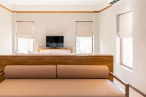 Innenansicht eines Schlafzimmers im Banana Fan Sea Resort mit Fernseher und Bett.