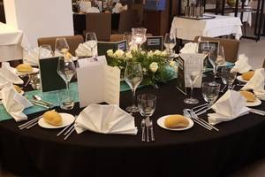 Rundes Essenstisch im Hotel Orangers Garden Villas & Bungalows mit gedeckten Plätzen, Geschirr, Besteck und Blumen.