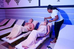 Spa-Massage im Club Wasa Holiday Village mit zwei Personen, eine Frau wird massiert.