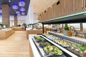 Innenraum des Arina Beach Resorts mit Buffet-Tisch, Holzboden und Beleuchtung.
