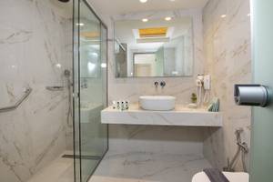 Badezimmer im Vantaris Luxury Beach Resort mit Marmorfliesen und moderner Einrichtung.