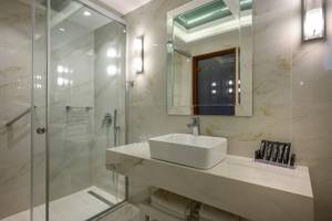Badezimmer im Vantaris Palace Hotel mit Marmorboden und weißen Fliesen.
