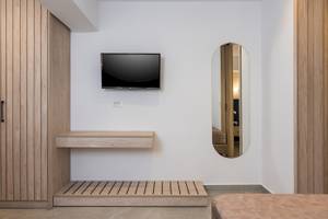 Innenansicht eines Zimmers im Vantaris Palace Hotel mit einer Wand, einem Fernseher und einem Spiegel.
