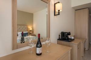 Zimmer im Vantaris Palace Hotel mit Bett, Weinflasche und Weingläsern