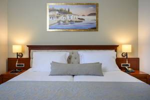 Bett im Vantaris Palace Hotelzimmer mit Dekor und Gemälde an der Wand