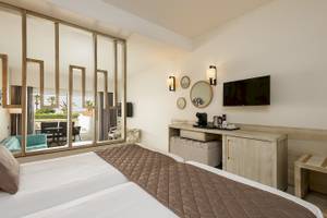 Doppelbettzimmer im Vantaris Palace Hotel mit Blick auf Terrasse und Garten.