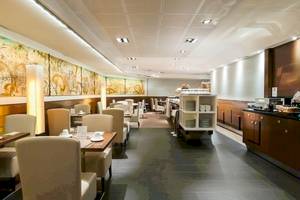 Frühstücksraum im Colonial Barcelona Hotel mit Tisch, Stühlen und Speisen.