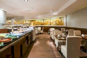 Innenansicht des Restaurants im Colonial Barcelona Hotel mit Buffet und Tischen.