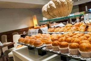 Frühstücksbuffet im Colonial Barcelona Hotel mit verschiedenen Brötchen, Croissants und Muffins.
