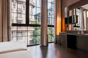 Innenansicht eines Zimmers im Colonial Barcelona Hotel mit Blick auf ein Gebäude.