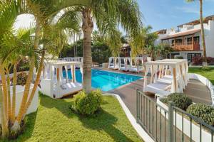Außenpoolbereich des Jardin Tecina Hotels mit weißen Sonnenbetten und Palmen