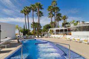 Poolbereich des Jardin Tecina Hotels mit vielen Liegestühlen und Palmen