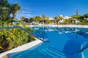 Außenpool des Jardin Tecina Hotels umgeben von tropischer Vegetation und Gebäuden