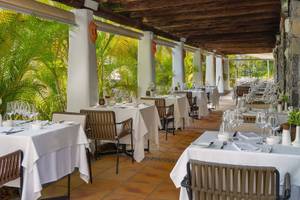 Innenansicht des Restaurants des Jardin Tecina Hotels mit gedeckten Tischen und Stühlen unter einer Holzdecke.