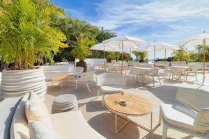 Terrasse des Jardin Tecina Hotels mit Tischen unter Schirmen und Pflanzen