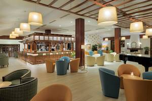 Innenbereich des Jardin Tecina Hotels mit Bar, Sitzbereichen und Klavier.