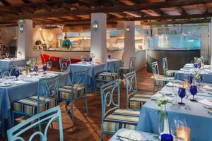 Innenansicht des Restaurants im Hotel Jardin Tecina mit blauen Tischen und Stühlen.