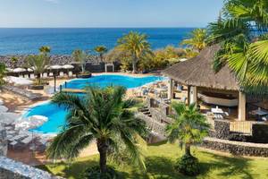 Oberansicht des Jardin Tecina Hotels mit Außenpool, Sonnenliegen und Blick auf das Meer.
