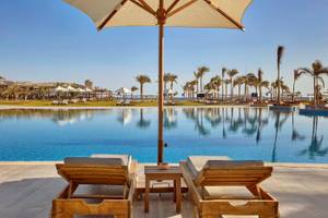 Poolbereich des Steigenberger Resorts Alaya mit zwei Liegen und einem Schirm
